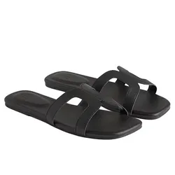 Black slide sandals with two thick straps featuring a cut-out design.
