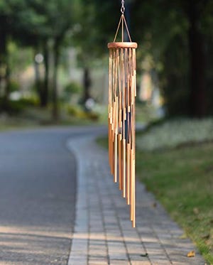 A 36-inch wind chime with wooden clapper and copper-brown tubes suspended from a circular wooden top, hanging outdoors.