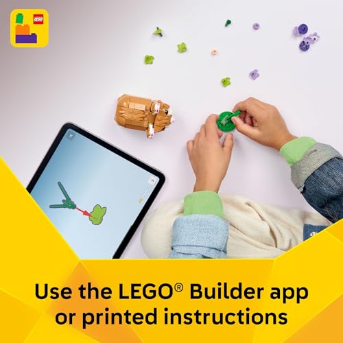 A pair of hands assembles a LEGO set using the LEGO Builder app on a tablet. Various LEGO pieces are scattered on a white surface alongside a yellow banner with the text \“Use the LEGO Builder app or printed instructions.\“