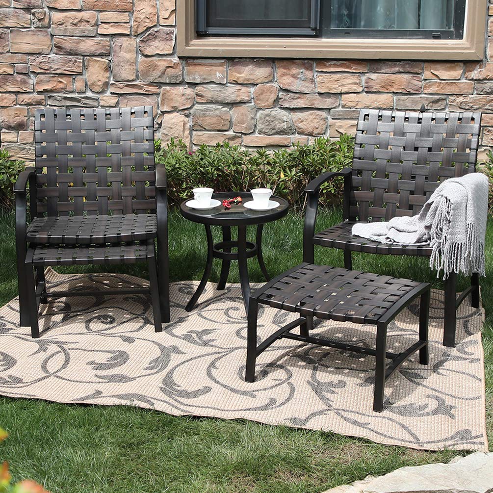 Outdoor furniture set including two woven chairs, a side table, and a matching ottoman on a patterned rug.