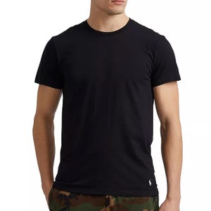 A man is wearing a plain black t-shirt paired with camouflage pants.