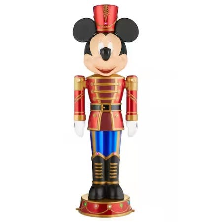 A figure resembling a famous mouse character dressed as a nutcracker soldier, featuring a red and gold uniform, blue pants, and a red hat.