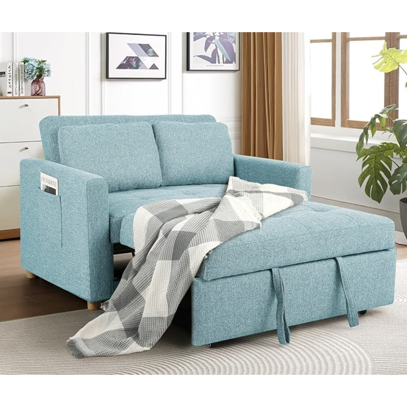 Blue sofa bed with adjustable backrest and storage chaise, draped with a gray and white checkered blanket; located in a cozy living room setting.