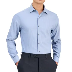 A man is wearing a light blue long-sleeve dress shirt with subtle vertical stripes, paired with dark trousers.