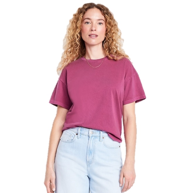 A person is wearing a short-sleeved magenta t-shirt paired with light blue jeans.