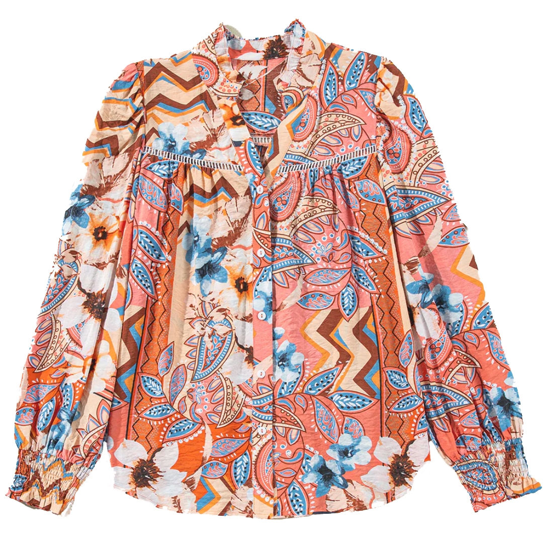 Colorful floral button-up shirt with a mixed pattern of leaves, flowers, and chevron stripes in shades of blue, orange, and white. Features long sleeves with gathered cuffs and a ruffled collar detail.