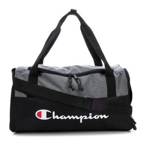 Champion duffel bag with a gray top and black bottom features black straps and two black zippers. The brand logo is prominently displayed on the side in white with a red accent.