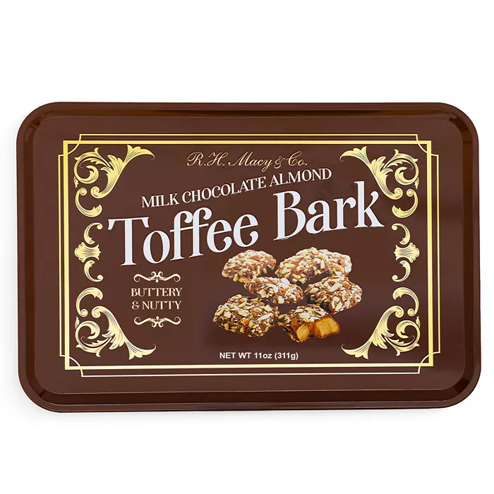 R.H. Macy & Co. Milk Chocolate Almond Toffee Bark is described as buttery and nutty, weighing 11 oz (311g). The packaging features a decorative design with pictures of the toffee bark pieces.