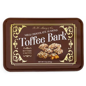 R.H. Macy & Co. Milk Chocolate Almond Toffee Bark is described as buttery and nutty, weighing 11 oz (311g). The packaging features a decorative design with pictures of the toffee bark pieces.