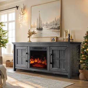 A cozy room features a gray wooden electric fireplace TV stand with a glowing flame effect, surrounded by holiday decorations including a Christmas tree and winter-themed artwork above.