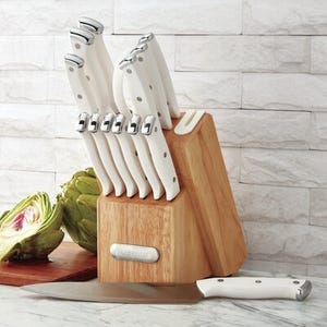 A set of white-handled Farberware knives is arranged in a wooden block, with one knife alongside; the set includes a built-in sharpener.