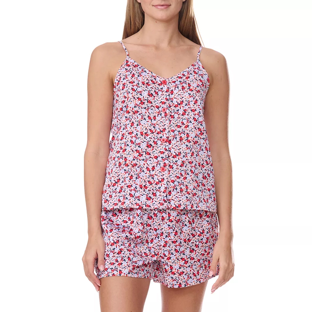 A woman is wearing a floral print pajama set featuring a sleeveless camisole top with thin straps and matching shorts. The pattern includes red, black, and white flowers.