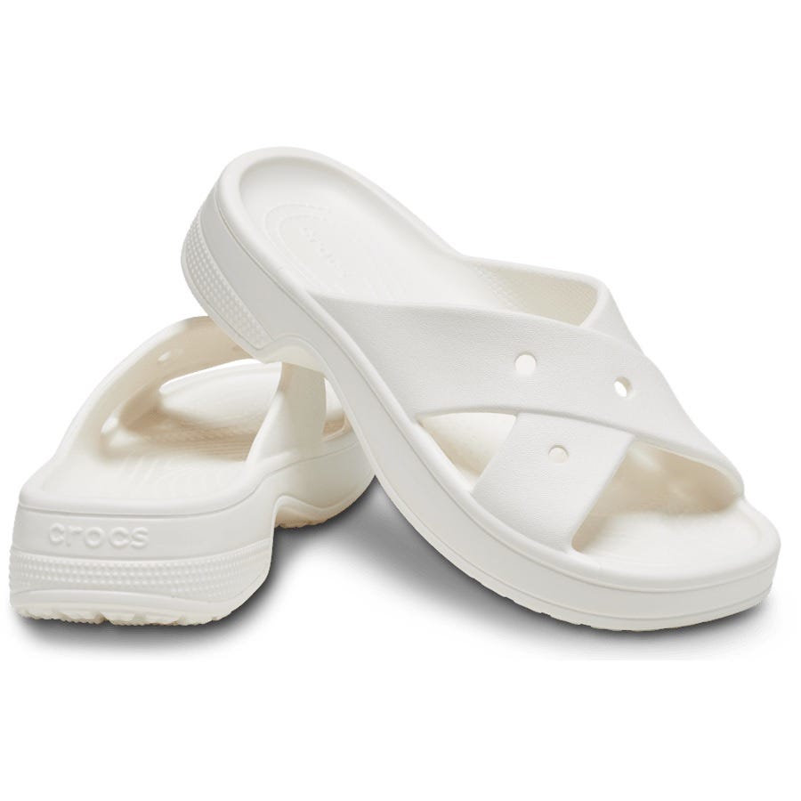 White Crocs Classic Cross Strap Sandals with a textured footbed and slip-on design, featuring two wide, overlapping straps with holes for breathability, and the Crocs logo on the side of the heel.
