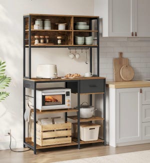 A kitchen rack with shelves, a toaster, microwave, cookware, and dishes.
