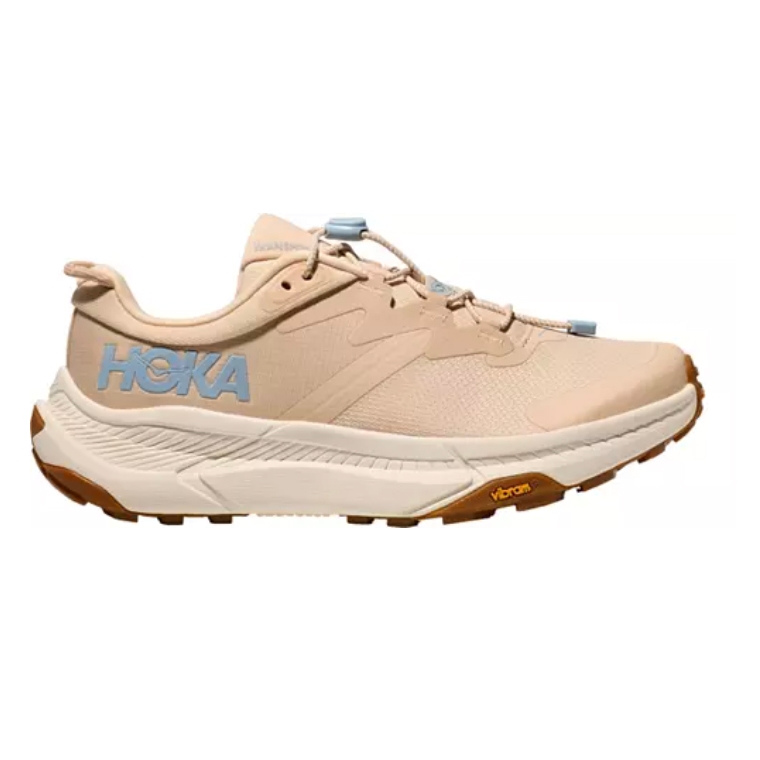 Hoka running shoe in beige with blue logo, featuring a Vibram sole and brown accents.