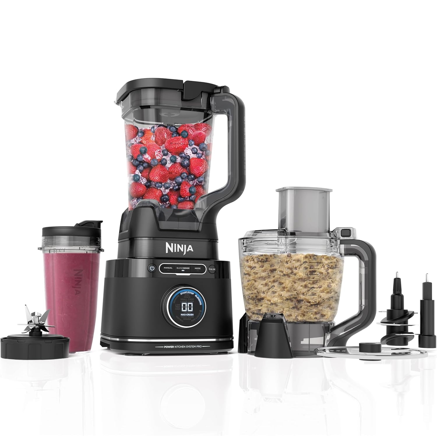 Ninja Blender System includes a blender with a pitcher filled with mixed berries, a food processor with ingredients, additional blades, and a personal blender cup containing a smoothie.
