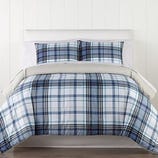 A blue and white plaid bedding set, including a comforter and two matching pillow shams, displayed on a neatly made bed.
