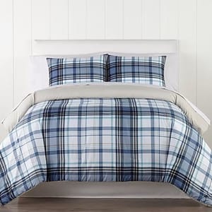 A blue and white plaid bedding set, including a comforter and two matching pillow shams, displayed on a neatly made bed.