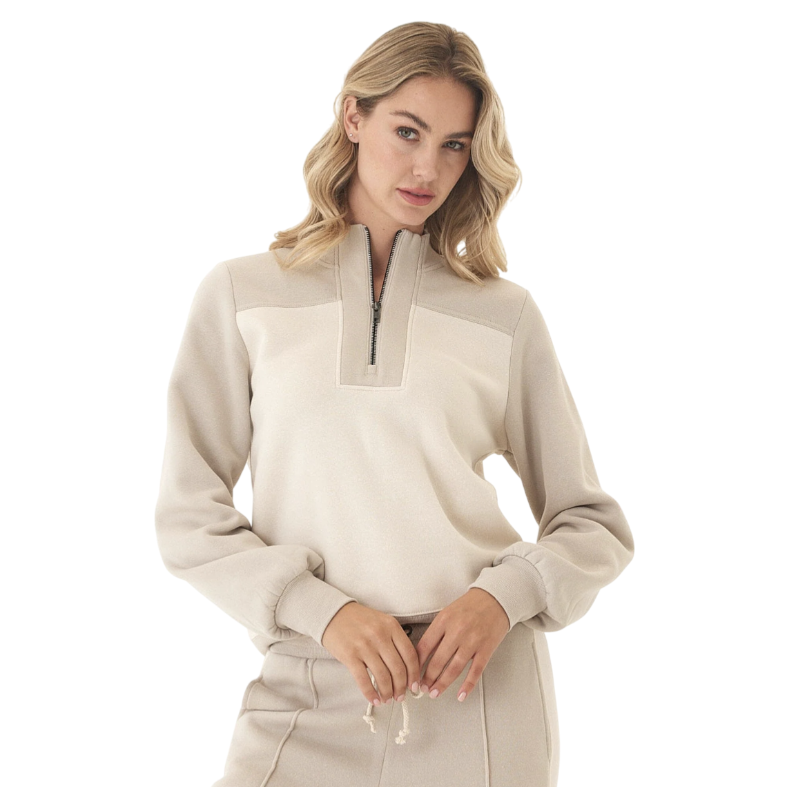 A woman is wearing a beige quarter-zip pullover with matching high-waisted pants featuring a drawstring.