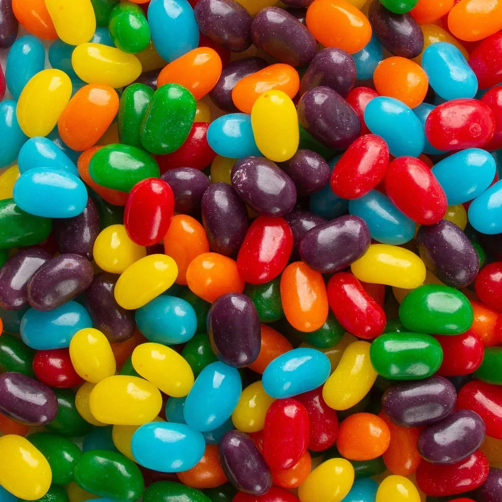 An assortment of colorful Jolly Rancher Jellybeans, including red, yellow, green, blue, orange, and purple, with a glossy finish.