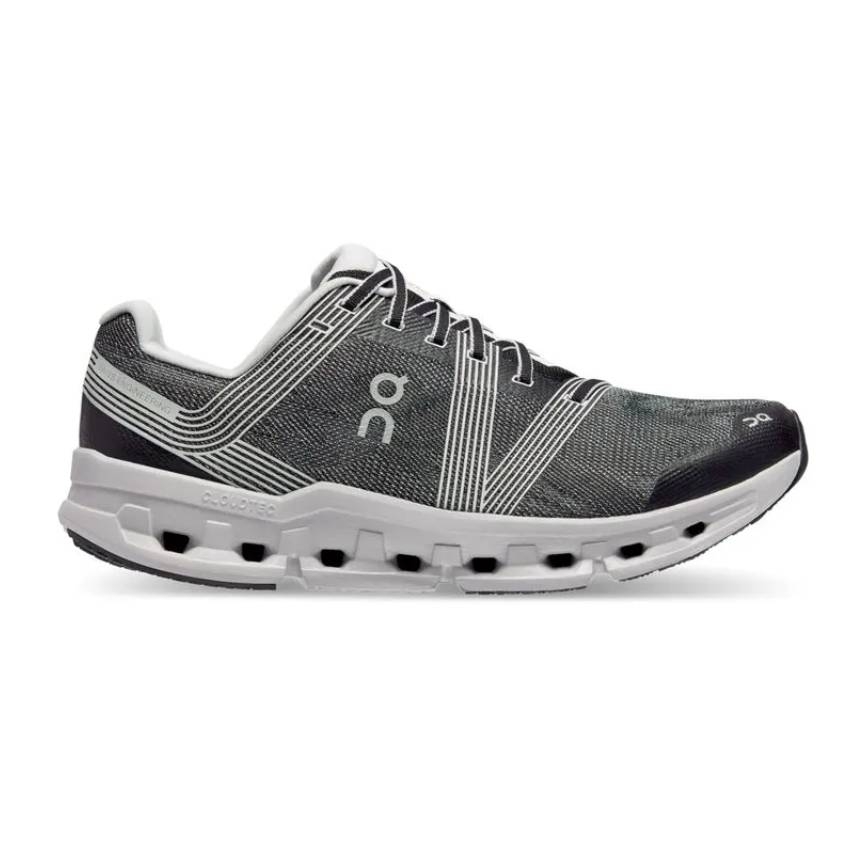 The On Running Cloudgo Shoes feature a lace-up design with a black and white upper and a distinctive white sole with separate cushion pods.