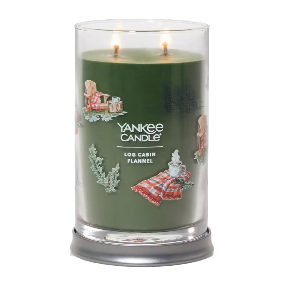 A large Yankee Candle with the scent \“Log Cabin Flannel,\“ showing two lit wicks and themed decorative imagery.