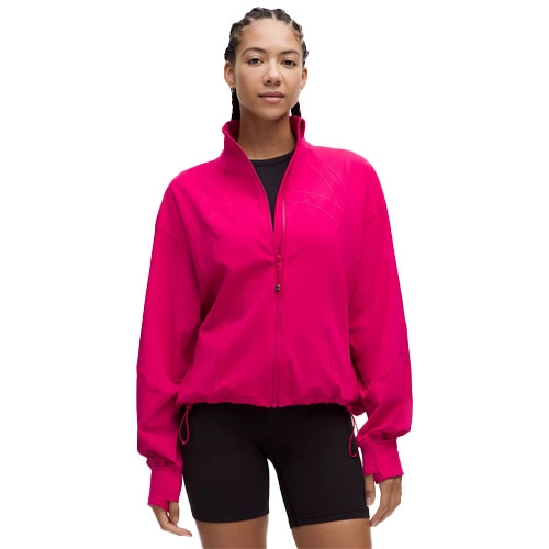 A vibrant pink jacket with a front zipper, high collar, and adjustable drawstrings at the hem and cuffs, paired with black shorts.