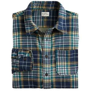 A folded plaid flannel shirt featuring blue, green, and yellow checkered patterns with a front pocket and button closure.