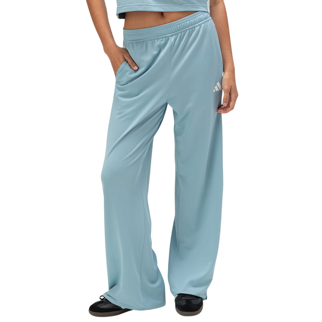 Light blue track pants with a wide-leg design and an Adidas logo, paired with black sneakers.