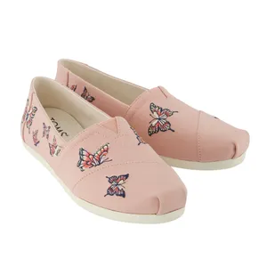 Pink slip-on shoes with multicolored butterfly embroidery.
