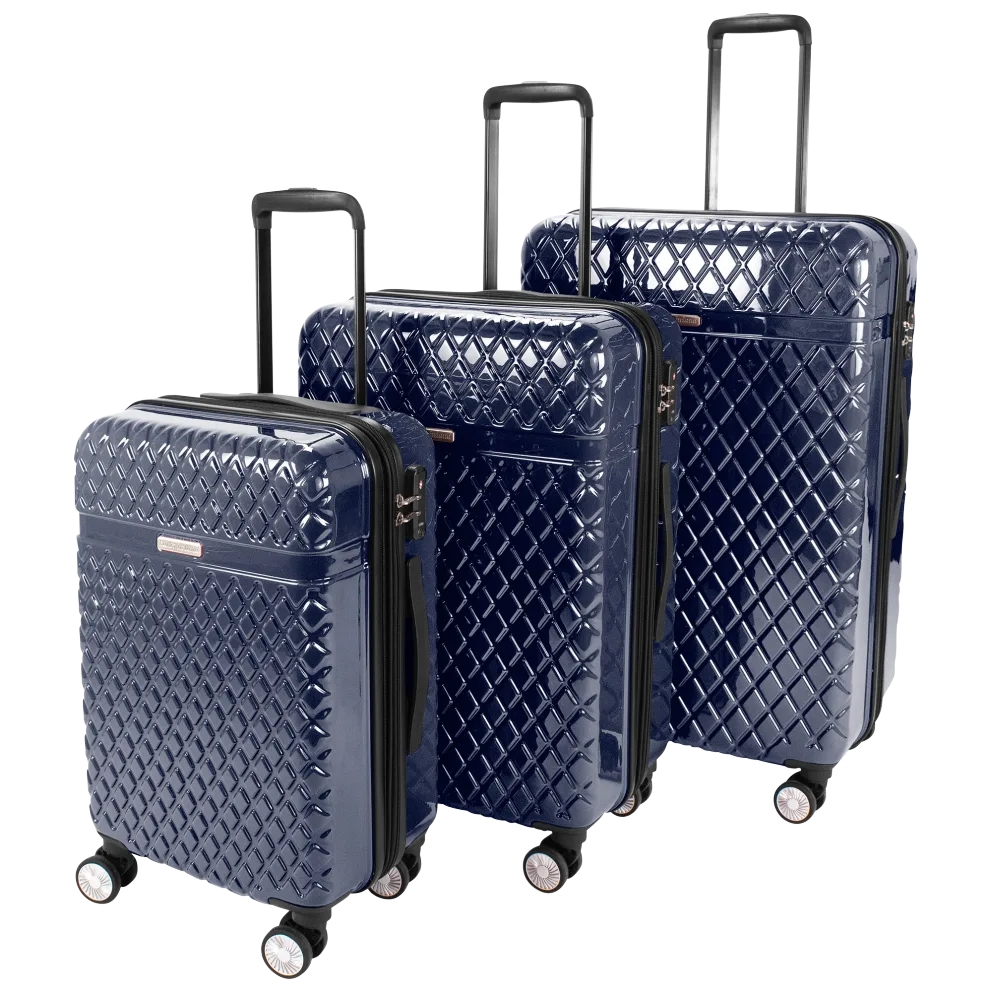 Three hard-sided Kathy Ireland suitcases in navy with a quilted diamond pattern, each featuring four spinner wheels and telescopic handles.
