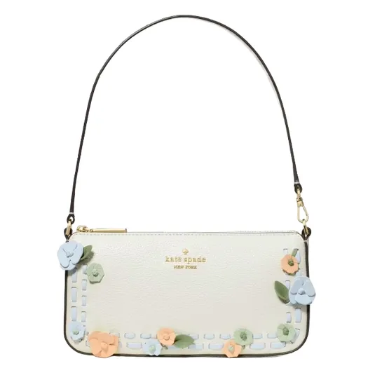 A white Kate Spade New York handbag adorned with colorful floral appliqués and a detachable black strap.