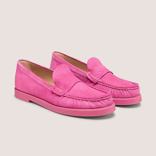 A pair of bright pink suede loafers with a traditional slip-on design and a prominent seam across the rounded toe.