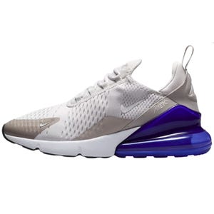 The Nike Air Max 270 features a mesh upper in white and beige tones, with a prominent purple Air unit in the heel for cushioning. The shoe includes white laces, a pull tab on the heel, and a sleek athletic design.