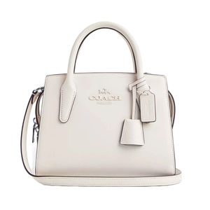 Coach Outlet Leather Carryall Bag in light beige features a structured design with dual top handles, detachable shoulder strap, embossed logo, and leather tag accents.