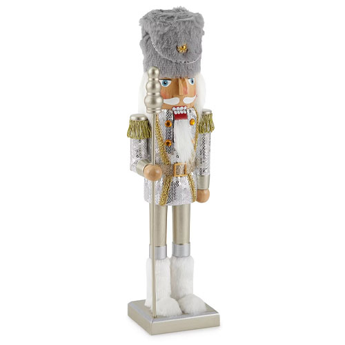 A silver and white Christmas nutcracker soldier dressed in a glittery uniform with a faux fur hat and gold shoulder tassels.