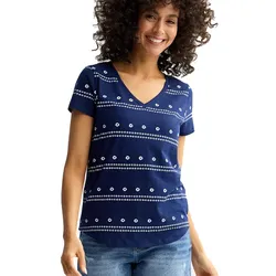A woman is wearing a navy blue V-neck T-shirt with white dotted horizontal stripes, paired with blue jeans.