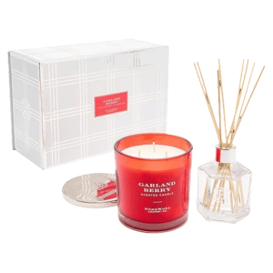 A Garland Berry scented candle and reed diffuser set, with the candle in a red glass container and the diffuser in a clear hexagonal bottle, accompanied by a decorative silver lid and a white box.