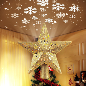 Glittery gold star tree topper projecting white snowflakes onto the ceiling, enhancing holiday decor.