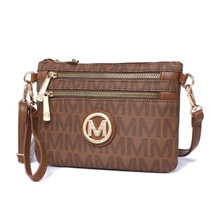 Brown crossbody bag with gold-tone zippers and hardware, featuring a decorative \“M\“ emblem with rhinestones on a patterned fabric.
