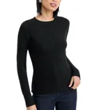A black ribbed sweater with subtle sparkle detail, worn with dark jeans.
