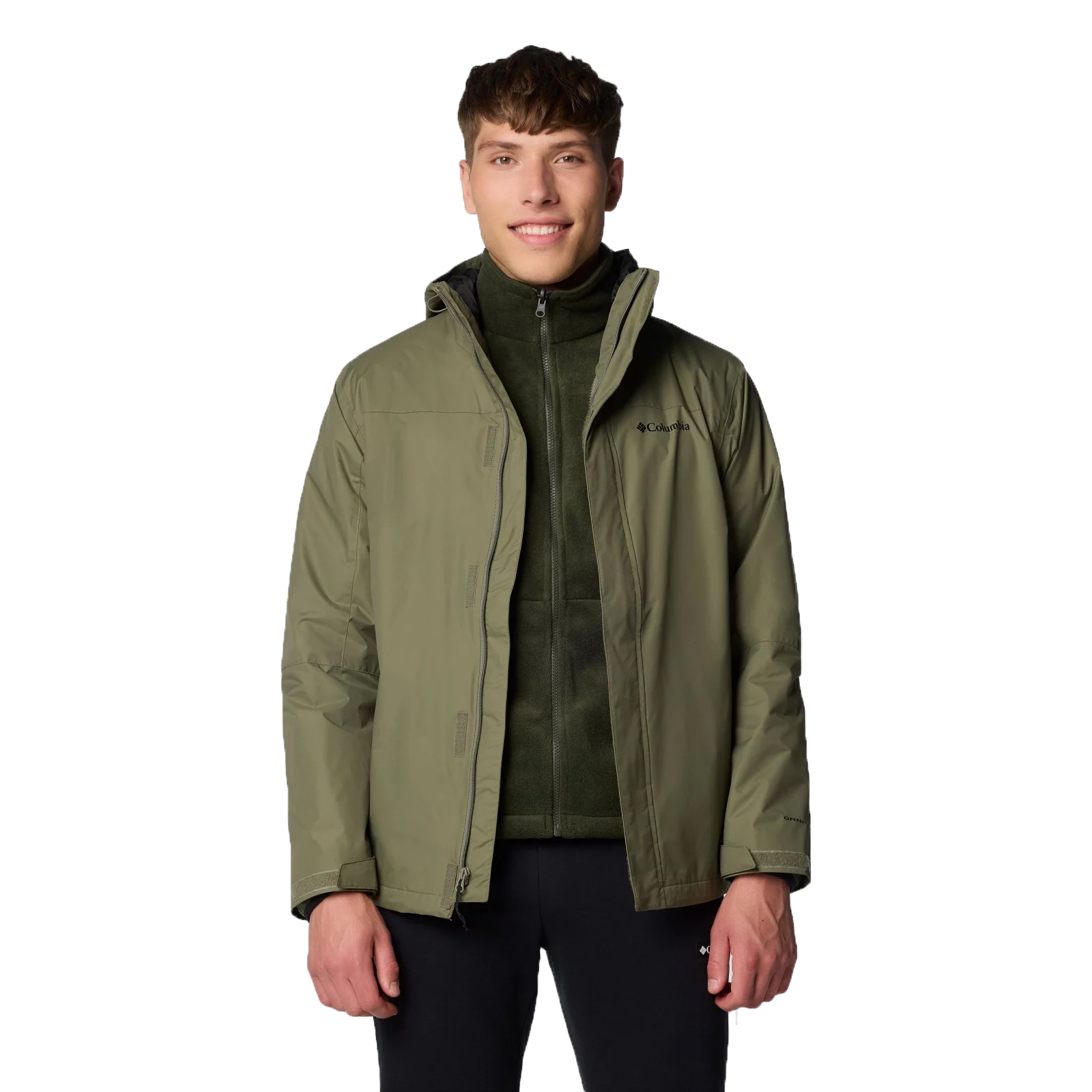 A person is wearing an olive green Columbia jacket over a zip-up fleece, paired with black pants.