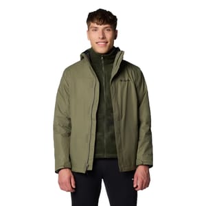 A person is wearing an olive green Columbia jacket over a zip-up fleece, paired with black pants.