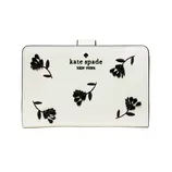 A white Kate Spade New York wallet features black floral embroidery and the brand logo on the front.