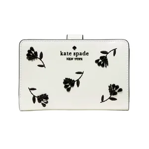 A white Kate Spade New York wallet features black floral embroidery and the brand logo on the front.
