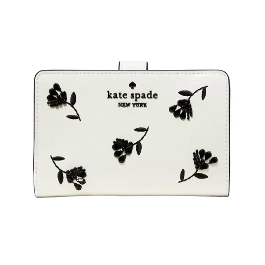 A white Kate Spade New York wallet features black floral embroidery and the brand logo on the front.