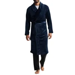 A man is wearing a dark blue robe with a shawl collar, tied at the waist, and black pants.
