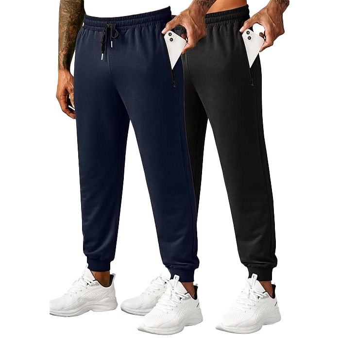 Two pairs of jogger pants, one in navy and one in black, featuring elastic waistbands with drawstrings, zippered pockets, and paired with white athletic shoes.