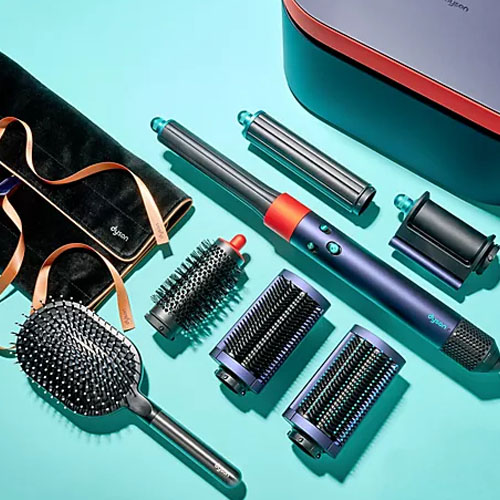 A collection of hair styling tools, including a hairdryer with attachments and various brushes, displayed on a turquoise background.