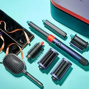 A collection of hair styling tools, including a hairdryer with attachments and various brushes, displayed on a turquoise background.